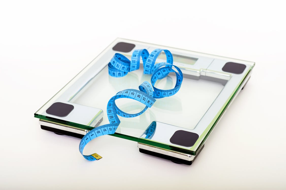 Blue measuring tape on a clear glass weighing scale