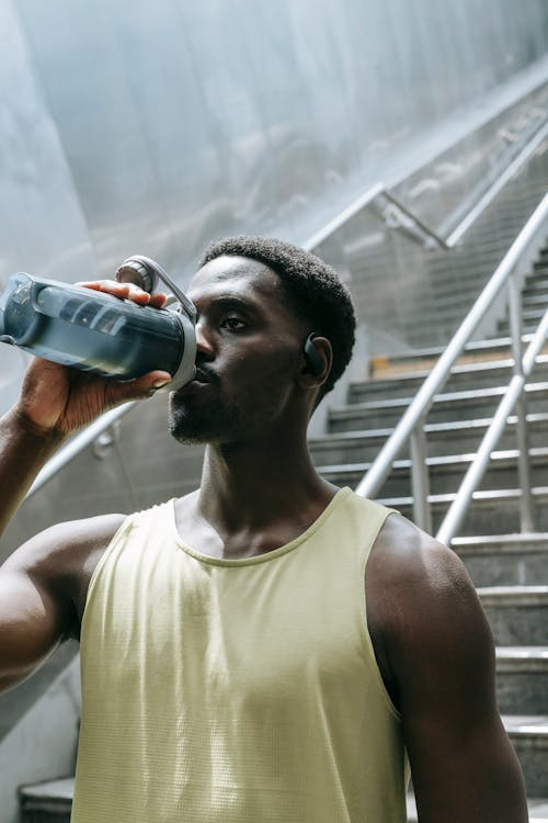  Man drinking water after a workout.