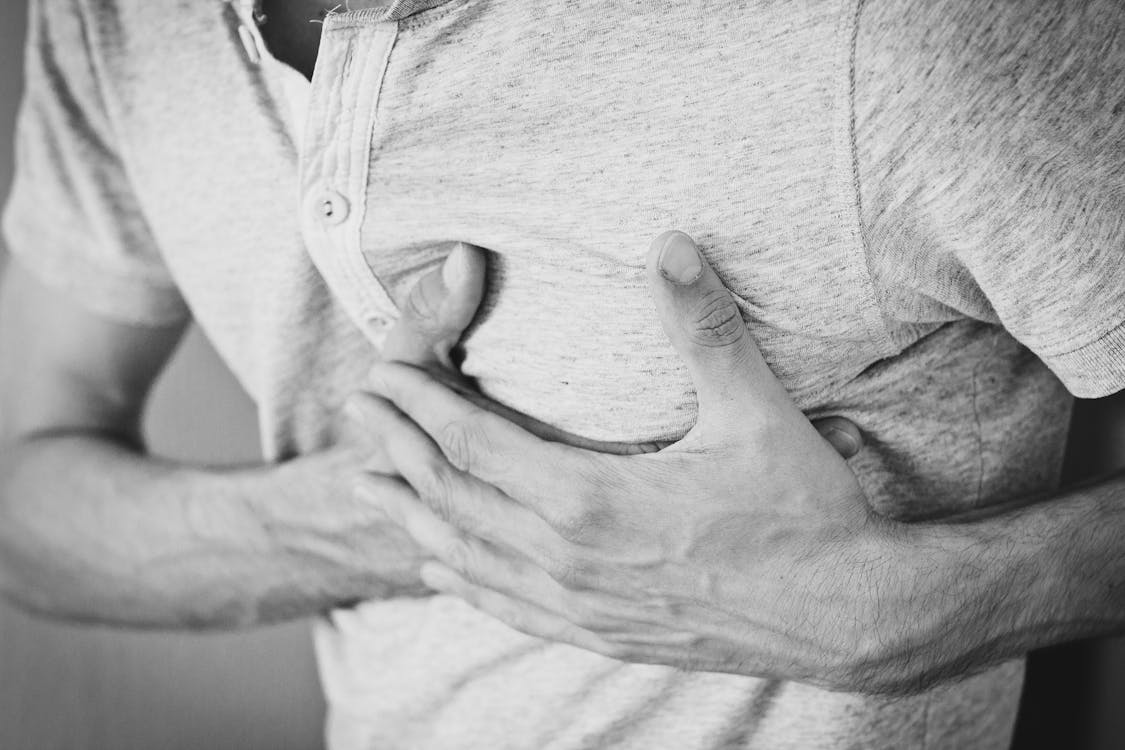 A man clutching his chest illustrating the cardiovascular risks of smoking.